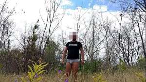 Handsome man is walking naked on the public park